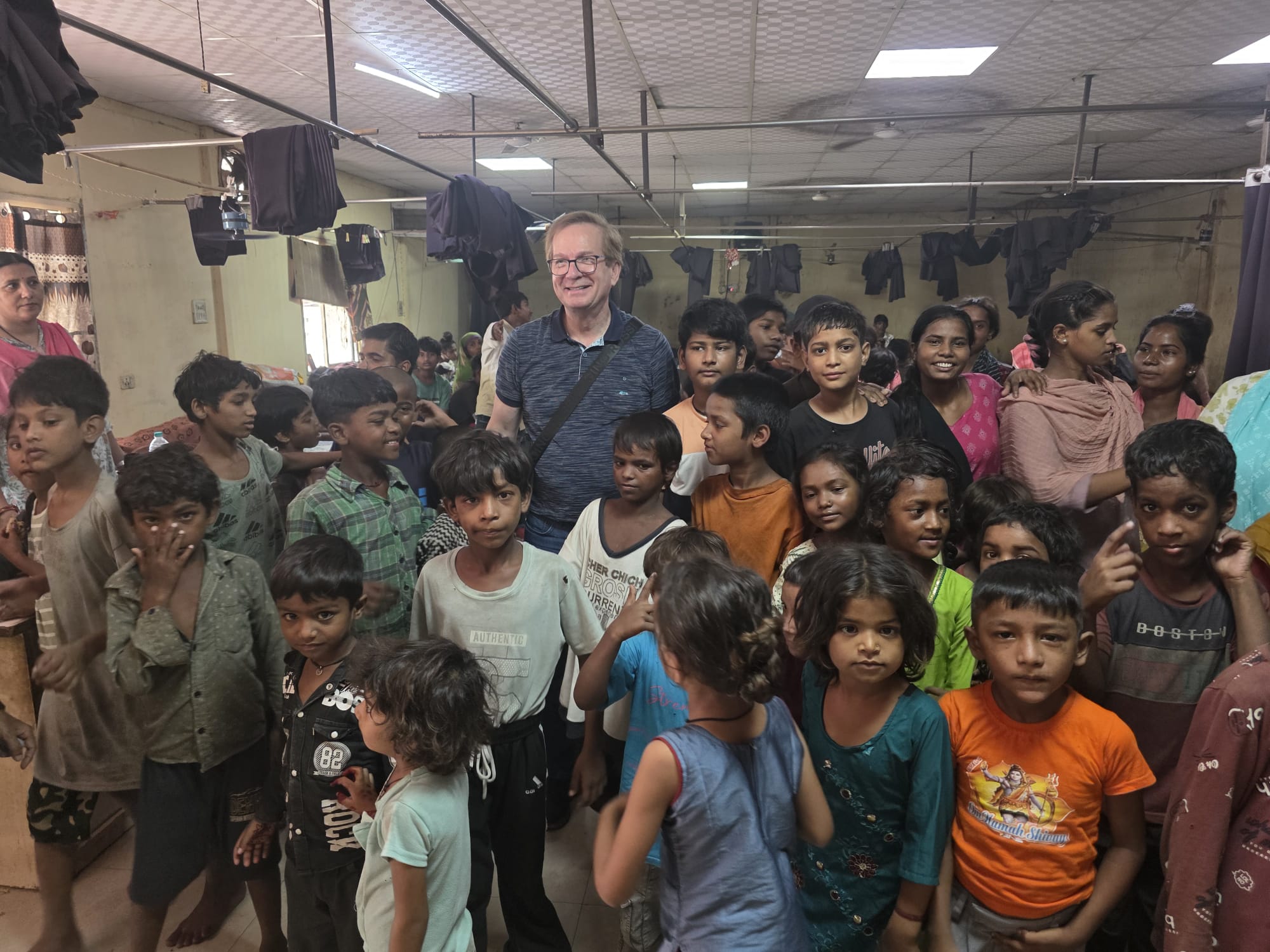A large group of children and adults in a community shelter room