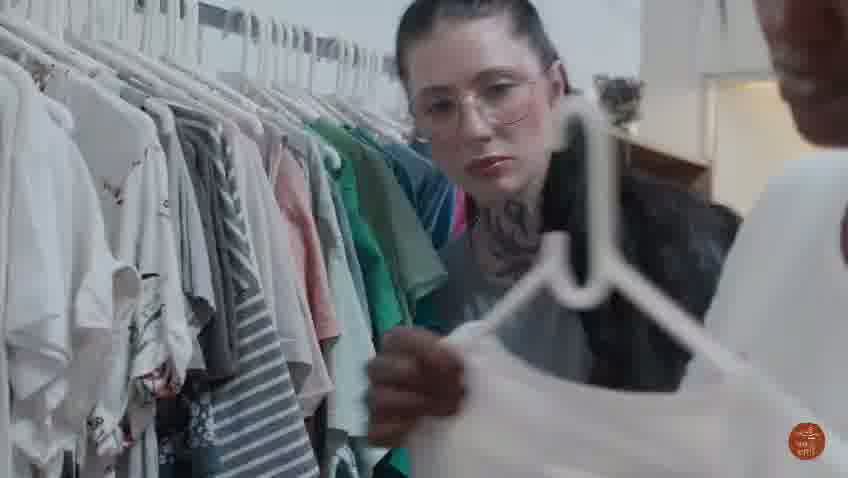 A Good Hope volunteer selecting donated clothing from a rack for distribution
