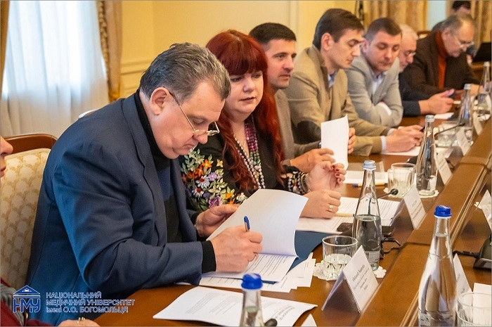Ukrainian professors reading and signing the memorandum documents at the meeting table