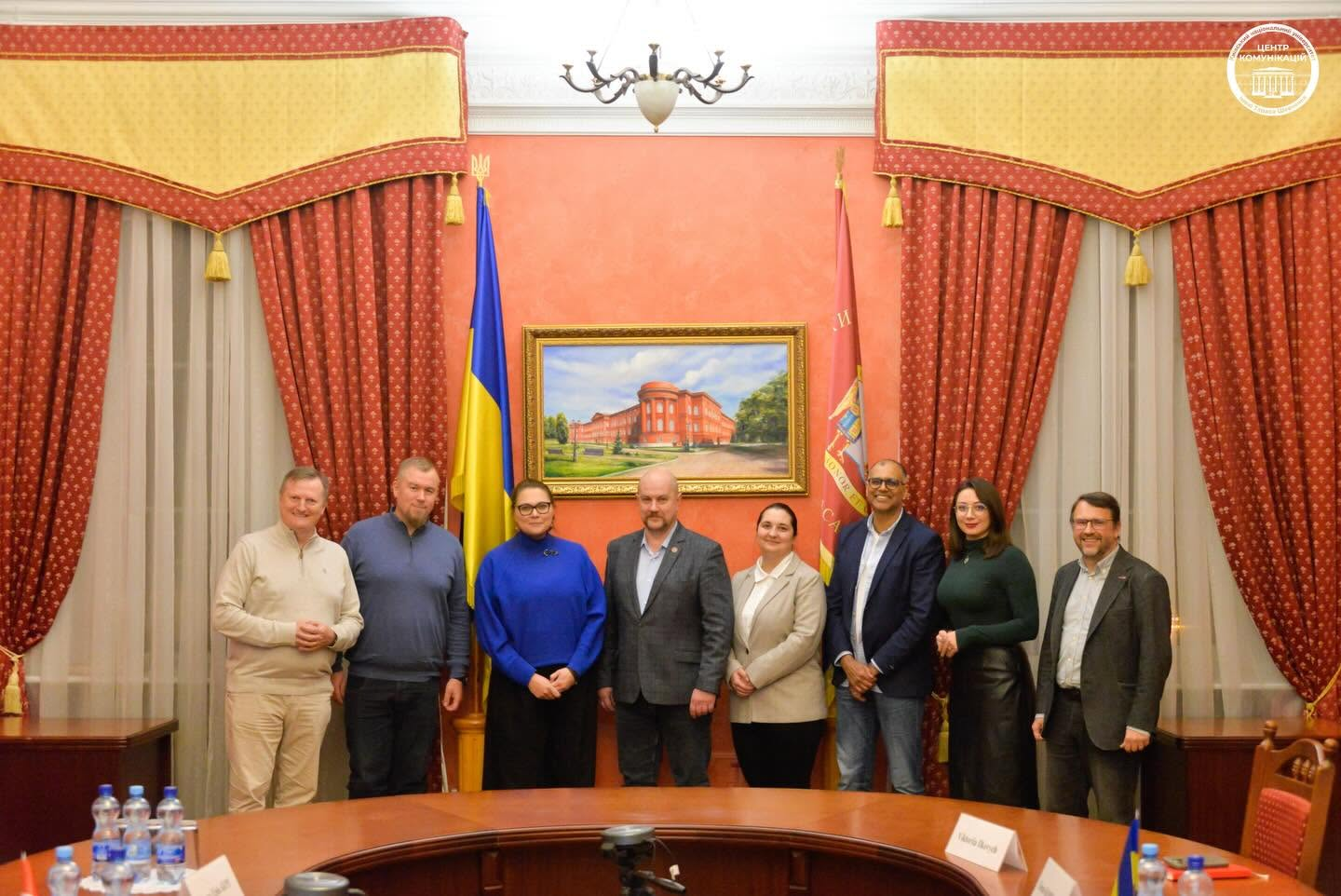Delegation with Ukrainian and university flags in a meeting room at Taras Shevchenko National University of Kyiv